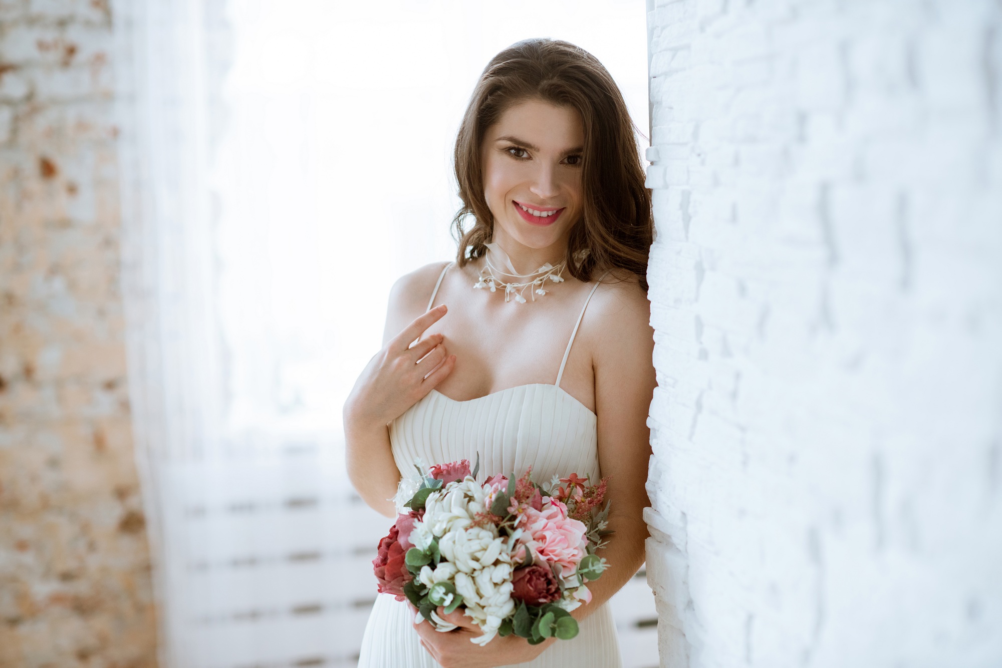 Brunette bride in fashion white wedding dress with makeup