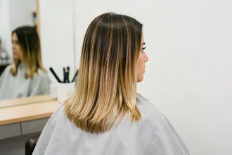 Femme aux cheveux mi-longs avec un dégradé naturel brun-miel en salon de coiffure