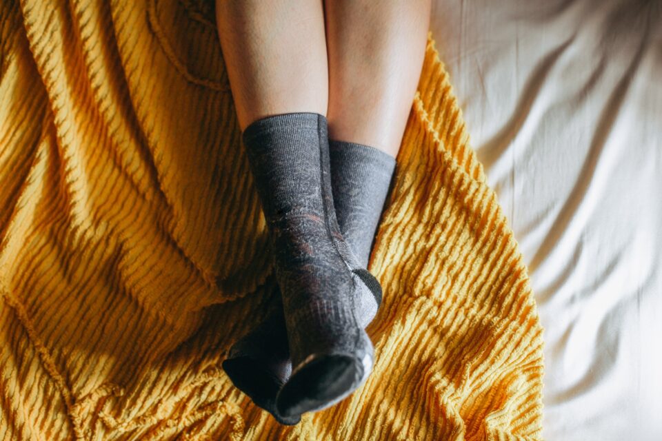 Foot wearing socks on the bed